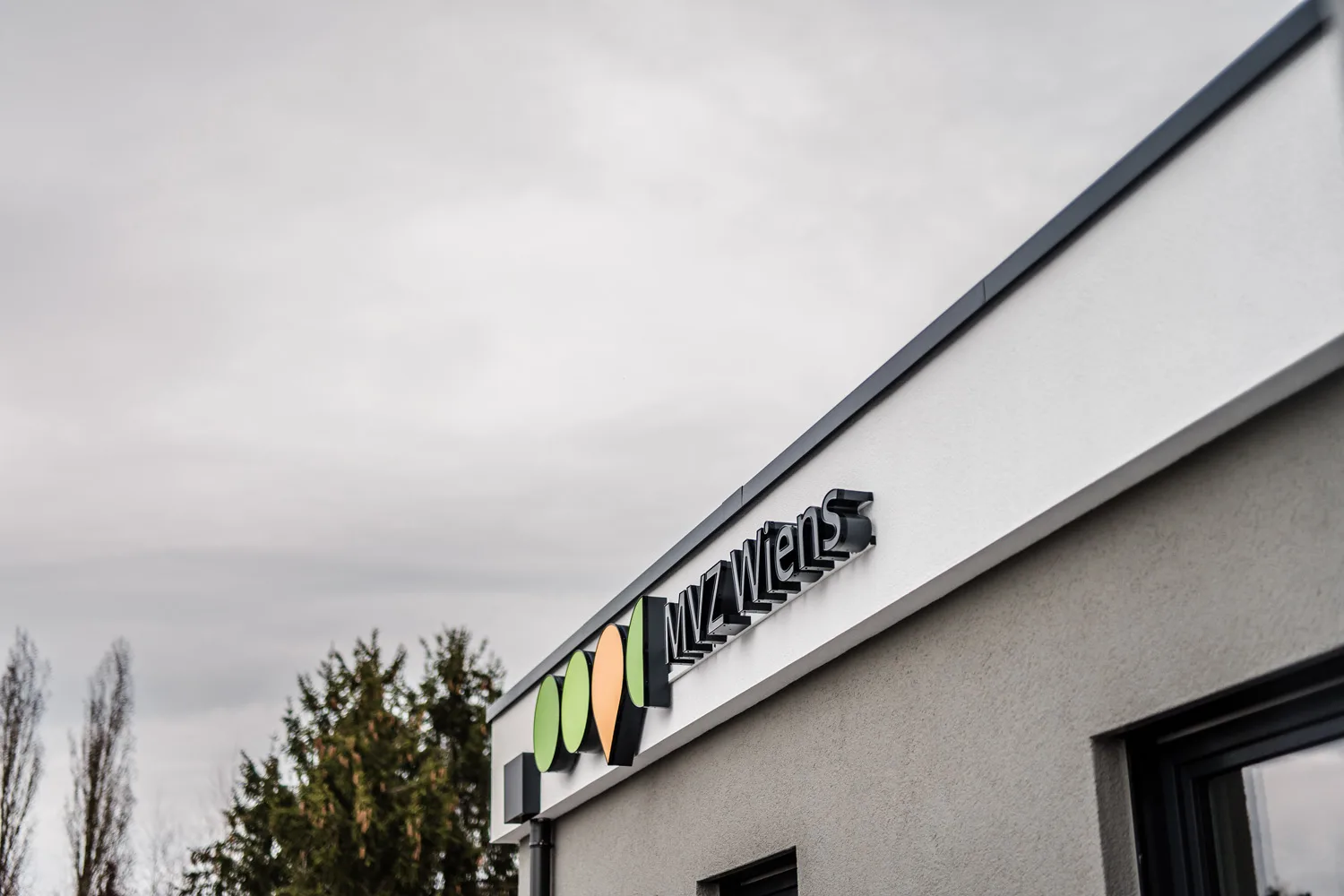 Praxisgebäude von außen mit beleuchtetem Schriftzug MVZ Wiens
